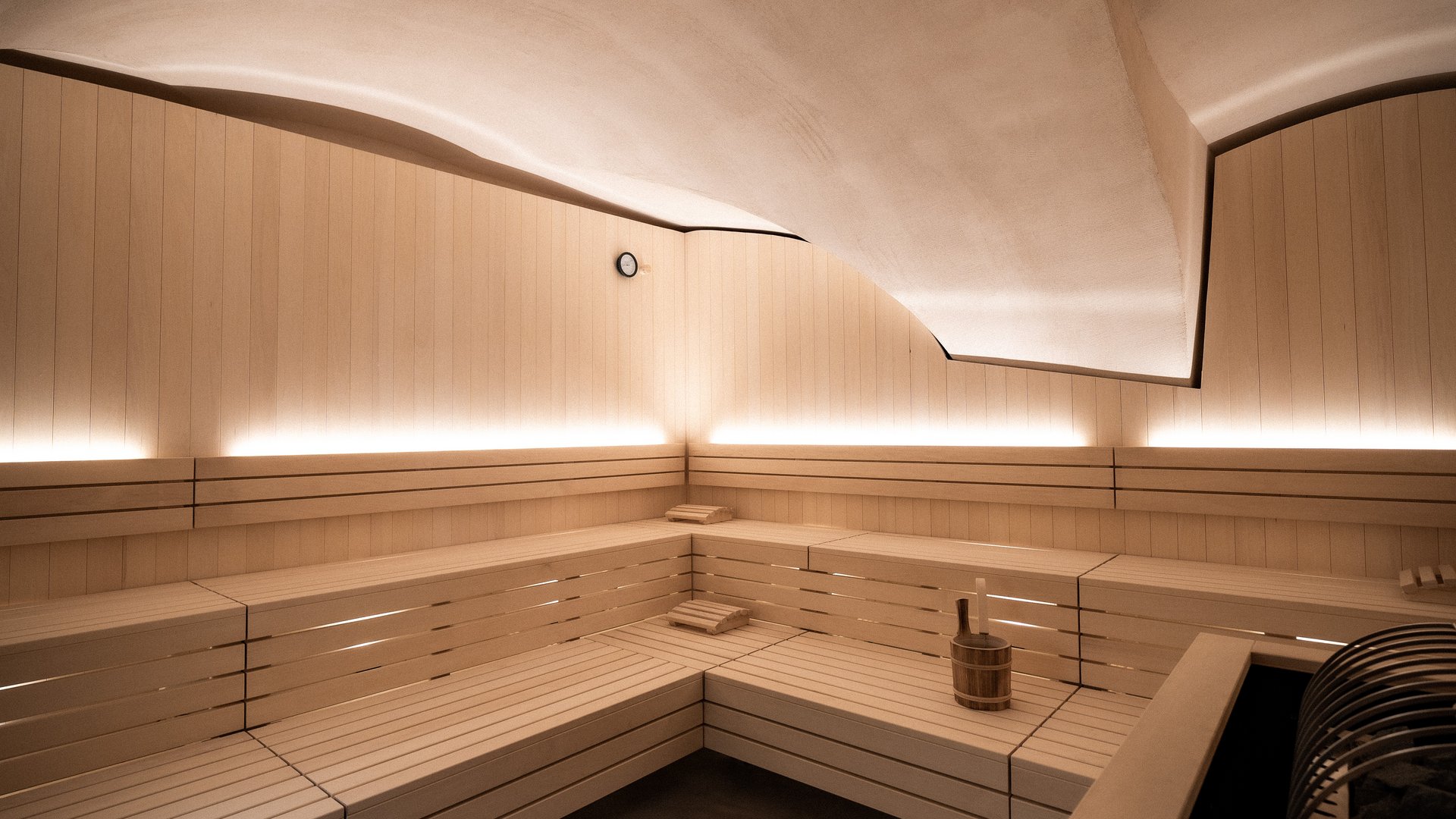 Modern sauna with wooden benches and indirect lighting